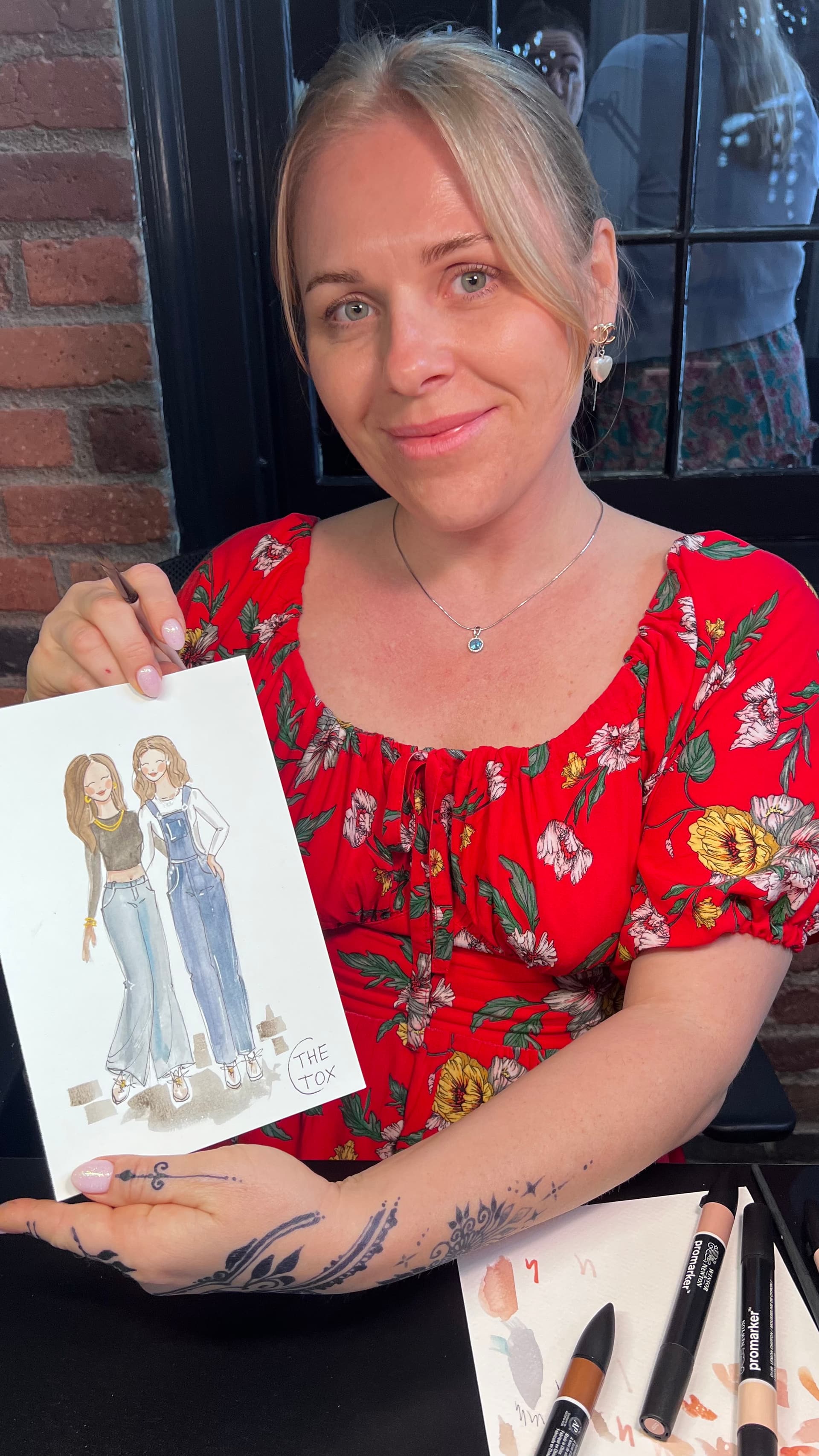 Fashion illustration artist showing a finished sketch of two friends